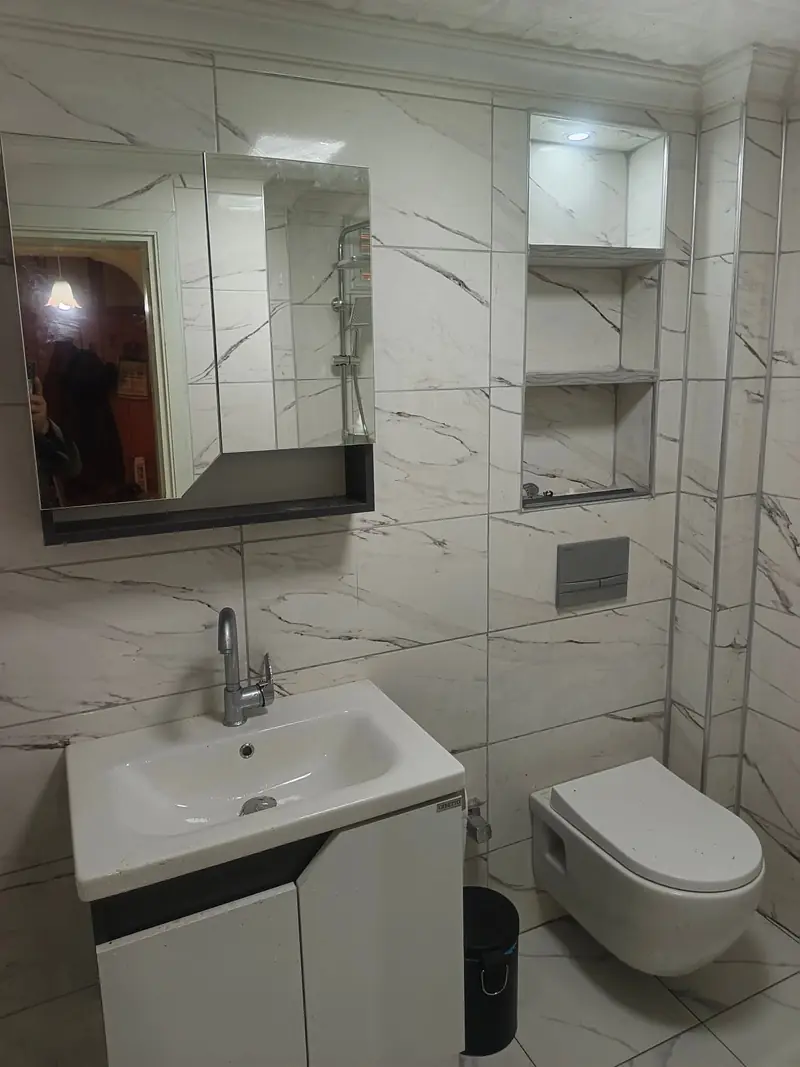 Tamamlanmış banyo: lavabo, ayna ve asma klozet