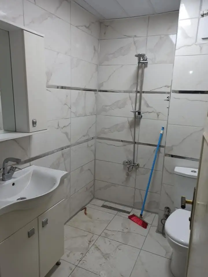 Beyaz mermer desenli banyo ve duş bölümü